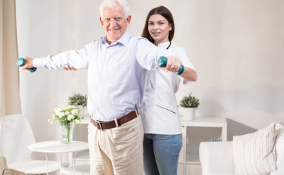 senior man doing exercise with caretaker